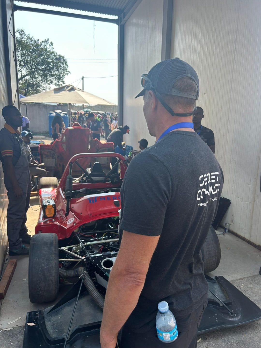 Mechanics checking a race car in the pit garage before the Grand Tour street race in Angola
